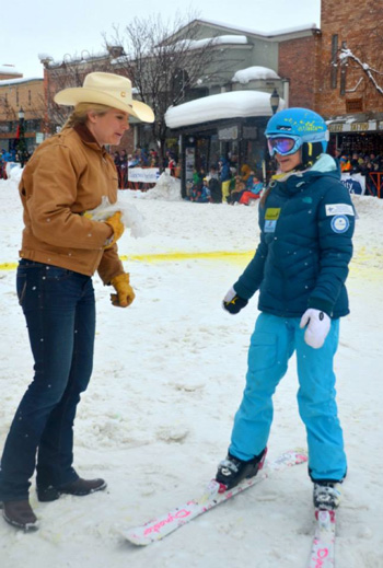 Lindsay from F.M. Light hands a Winter Carnival participant a sheriff's badge in Steamboat