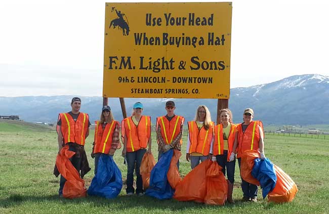F.M. Light and Sons cleans up highway 131 outside of Steamboat Springs, CO - posing in front of famous yellow road sign